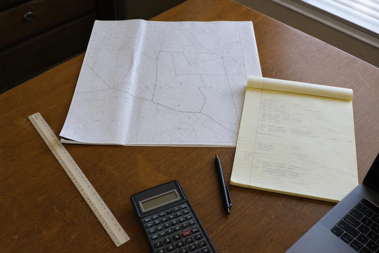 Parcel maps and acquisition notes on a working desk